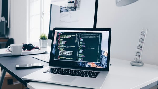 Notebook e ambiente de desenvolvimento de software em uma mesa de trabalho