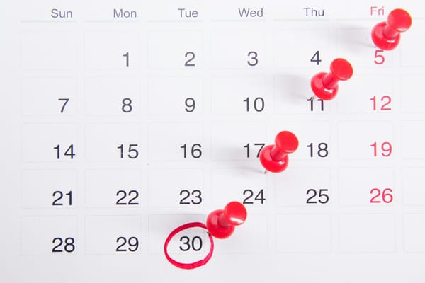 Calendário com marcações de compromissos, ilustrando organização de horários em negócios