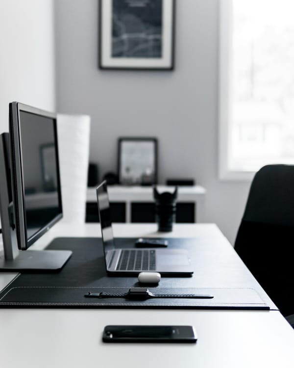 Notebook aberto sobre uma mesa de trabalho com acessórios de escritório